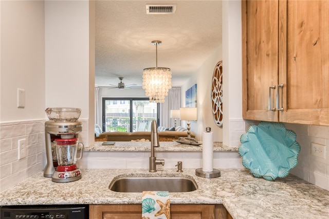 kitchen featuring pendant lighting, tasteful backsplash, a textured ceiling, dishwasher, and sink