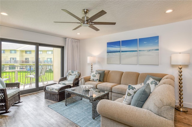 living area with a ceiling fan, recessed lighting, a textured ceiling, and wood finished floors