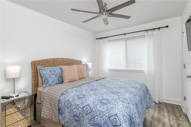 bedroom with a textured ceiling, ceiling fan, and hardwood / wood-style flooring