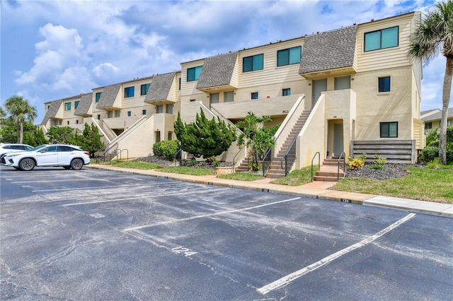 uncovered parking lot featuring a residential view and stairway