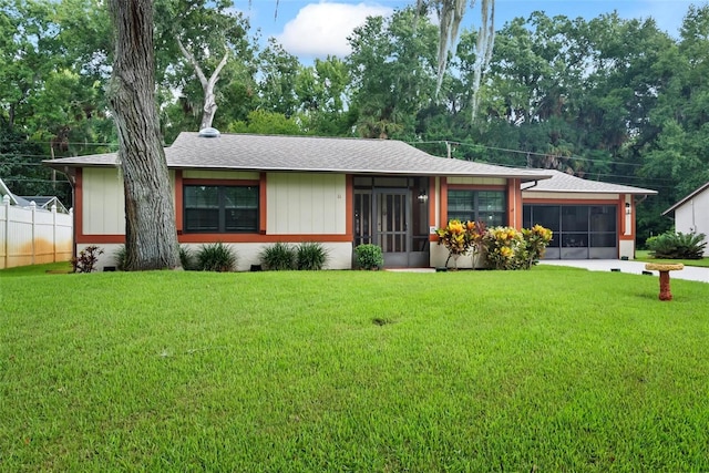 ranch-style house featuring a front yard and a sunroom