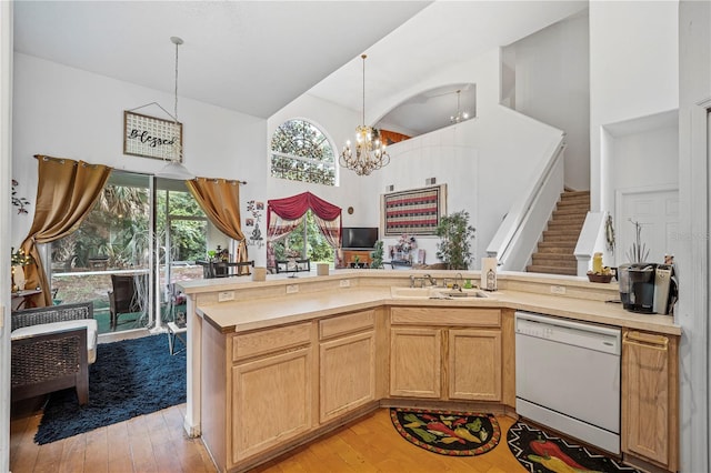 kitchen with light wood-type flooring, an inviting chandelier, dishwasher, and pendant lighting