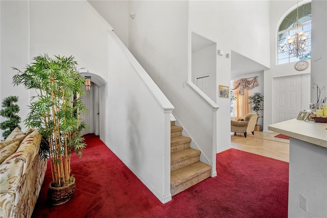 carpeted foyer with a towering ceiling