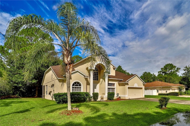 mediterranean / spanish-style home featuring a garage and a front lawn