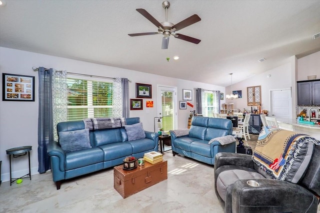 living room featuring ceiling fan with notable chandelier, lofted ceiling, and a textured ceiling