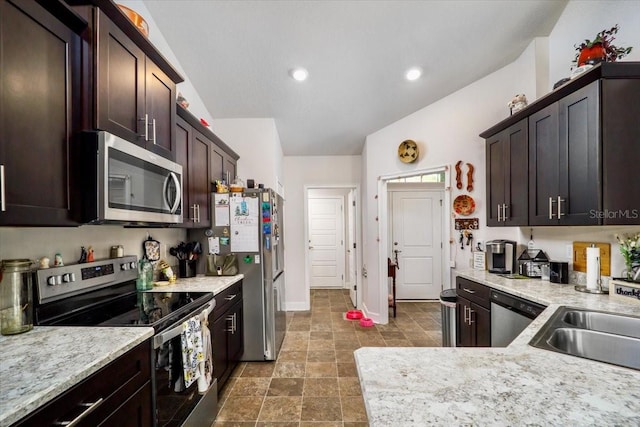 kitchen featuring light stone countertops, stainless steel appliances, dark brown cabinetry, and sink