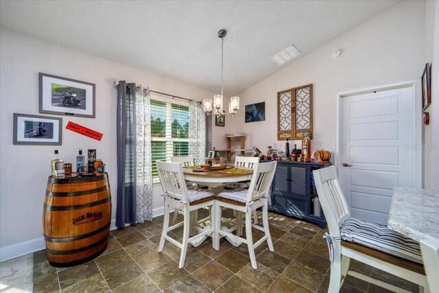 dining area featuring lofted ceiling and a notable chandelier