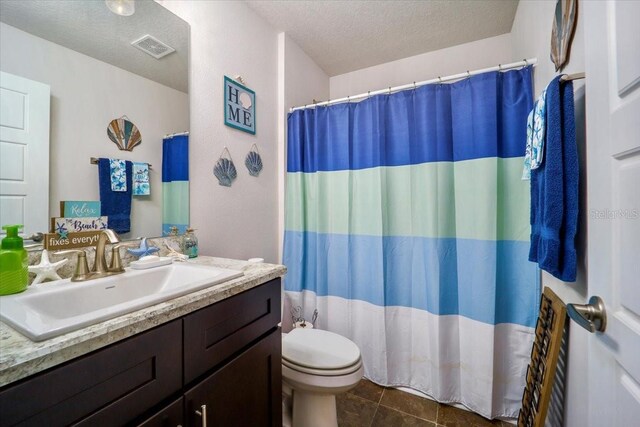 bathroom with toilet, walk in shower, tile patterned flooring, vanity, and a textured ceiling