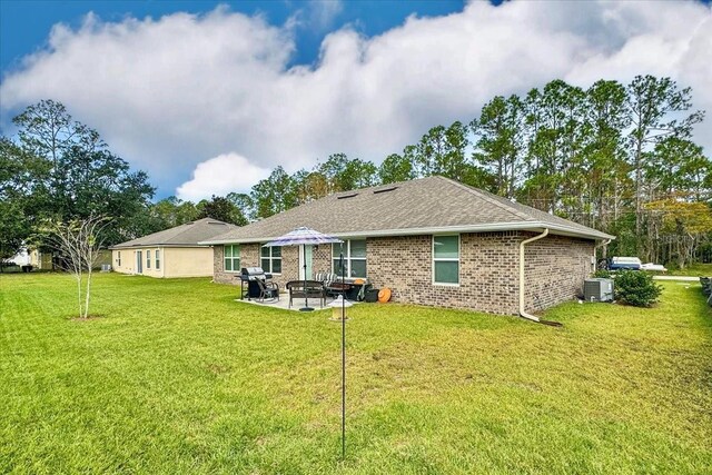 back of property featuring a yard, central AC unit, and a patio