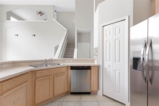 kitchen featuring appliances with stainless steel finishes, light brown cabinets, light tile patterned flooring, and sink