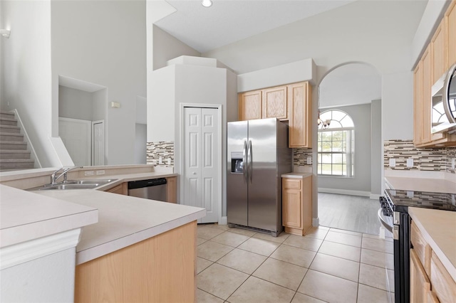 kitchen featuring tasteful backsplash, light tile patterned floors, stainless steel appliances, sink, and light brown cabinets