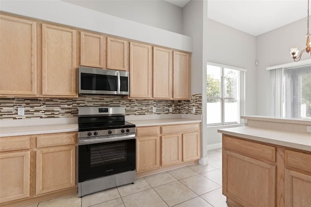 kitchen featuring hanging light fixtures, light brown cabinetry, appliances with stainless steel finishes, and light tile patterned flooring