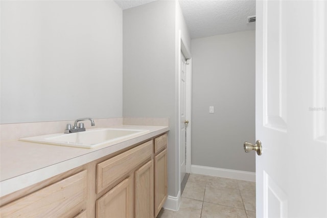 bathroom with tile patterned flooring, vanity, and a textured ceiling