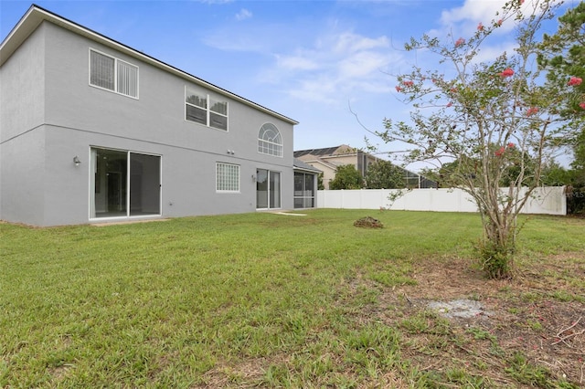 rear view of property featuring a lawn