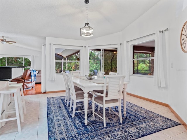 dining space with ceiling fan with notable chandelier, vaulted ceiling, a textured ceiling, and light hardwood / wood-style floors