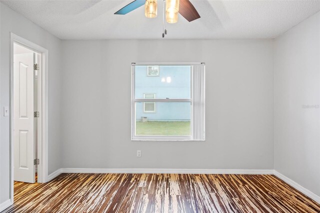 empty room featuring a textured ceiling, ceiling fan, and wood-type flooring