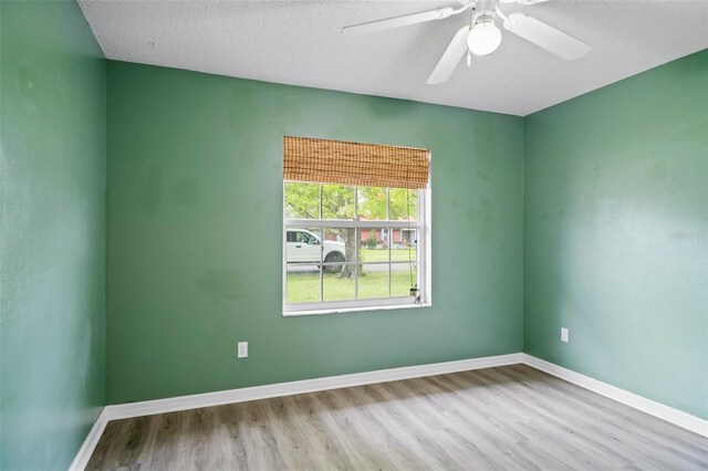 empty room featuring light wood-type flooring, ceiling fan, and a textured ceiling