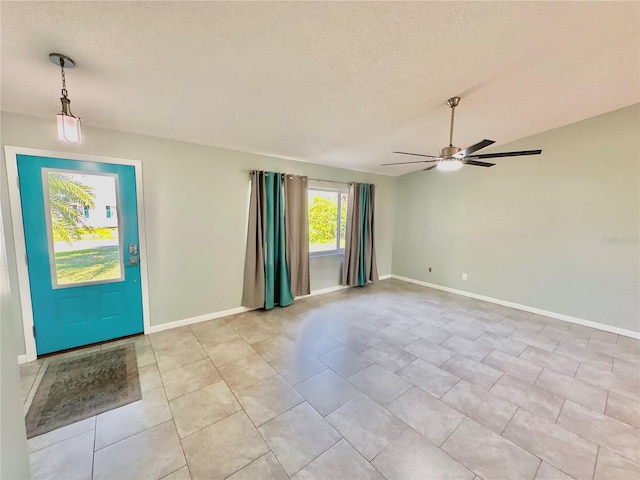 foyer entrance featuring ceiling fan, a textured ceiling, and light tile patterned floors