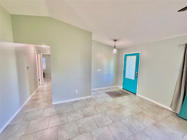 foyer with light tile patterned floors and vaulted ceiling