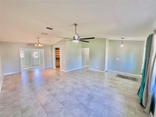 interior space with ceiling fan with notable chandelier, lofted ceiling, a textured ceiling, and light tile patterned flooring