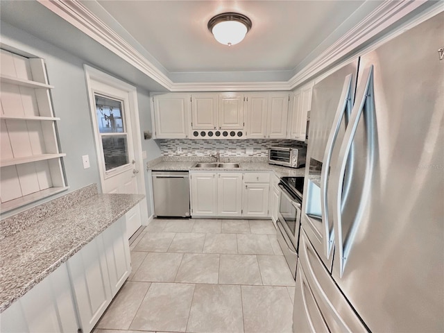 kitchen featuring light stone counters, tasteful backsplash, sink, white cabinets, and appliances with stainless steel finishes