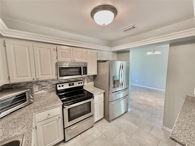 kitchen with light tile patterned flooring, backsplash, white cabinetry, stainless steel appliances, and a notable chandelier