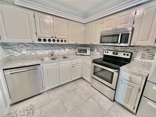 kitchen featuring backsplash, light tile patterned floors, stainless steel appliances, ornamental molding, and sink