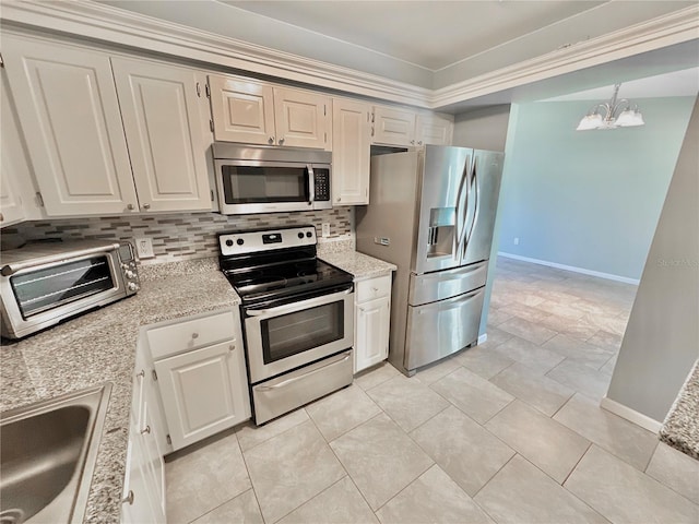 kitchen with appliances with stainless steel finishes, decorative backsplash, white cabinetry, and an inviting chandelier