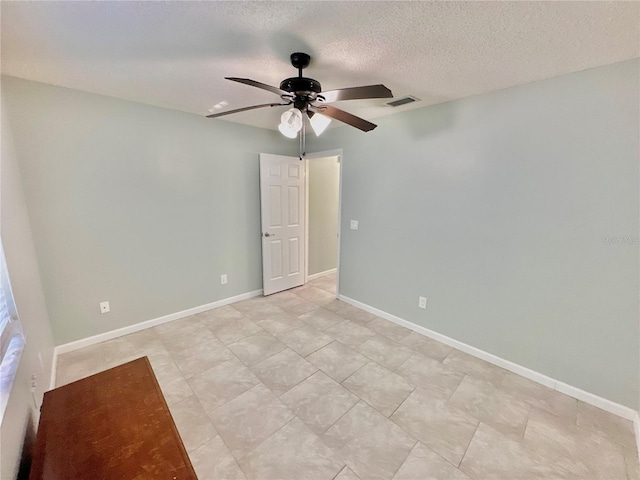 unfurnished room with ceiling fan and a textured ceiling