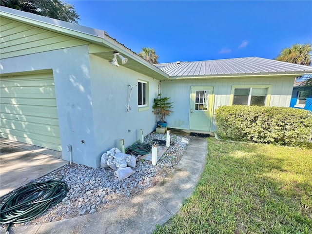 view of side of home featuring a garage and a lawn