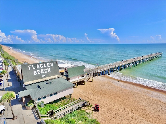 birds eye view of property with a water view and a beach view