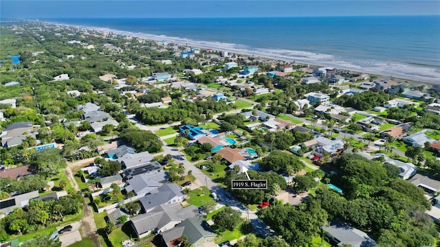 birds eye view of property featuring a water view and a beach view