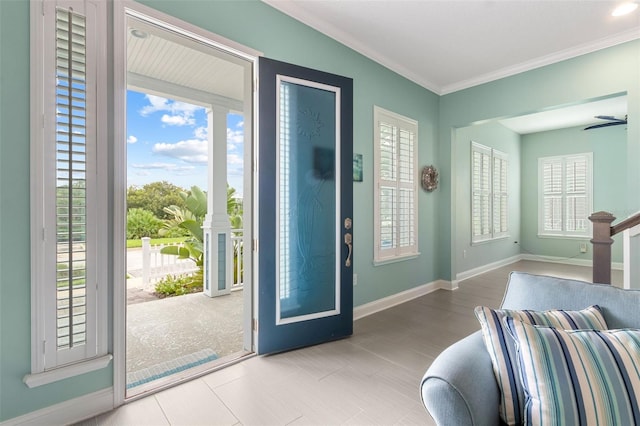 entrance foyer featuring ceiling fan and ornamental molding