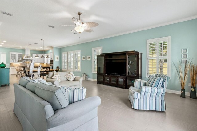 living room featuring ceiling fan and crown molding