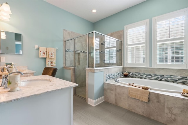 bathroom featuring a bath, a stall shower, and vanity