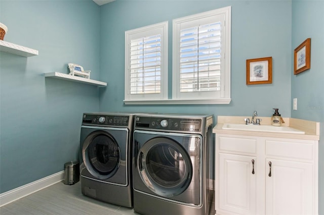 laundry room with cabinets, independent washer and dryer, and sink