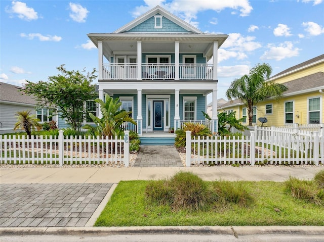 view of front of home featuring a fenced front yard, a porch, and a balcony