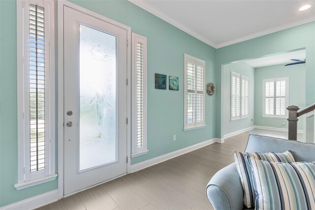 doorway with ceiling fan and ornamental molding