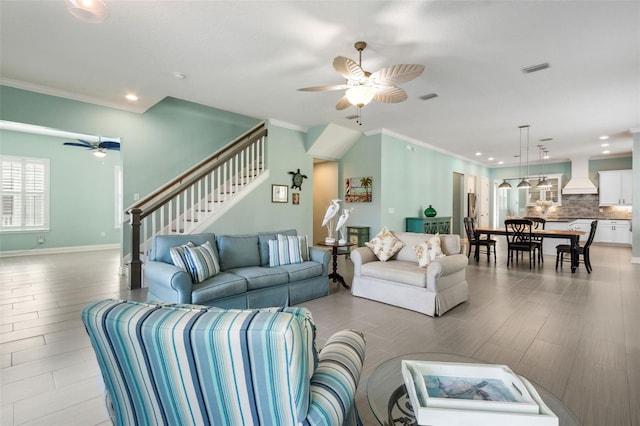 living room featuring ceiling fan and crown molding