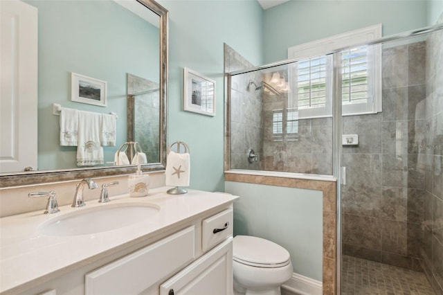 full bathroom featuring a shower stall, toilet, and vanity