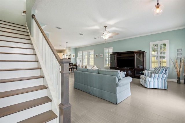 living room featuring ceiling fan and crown molding