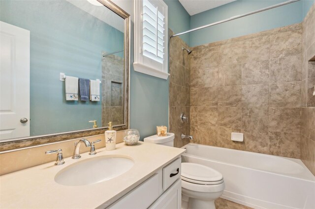 full bathroom with toilet, tiled shower / bath combo, and vanity