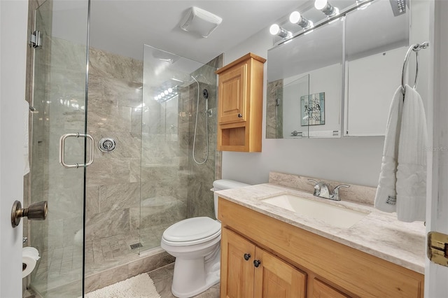 bathroom featuring vanity, toilet, a shower with door, and tile patterned floors