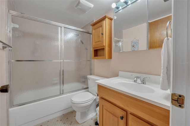 full bathroom with shower / bath combination with glass door, vanity, toilet, and tile patterned floors