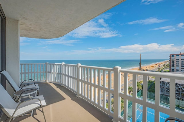 balcony with a water view and a beach view