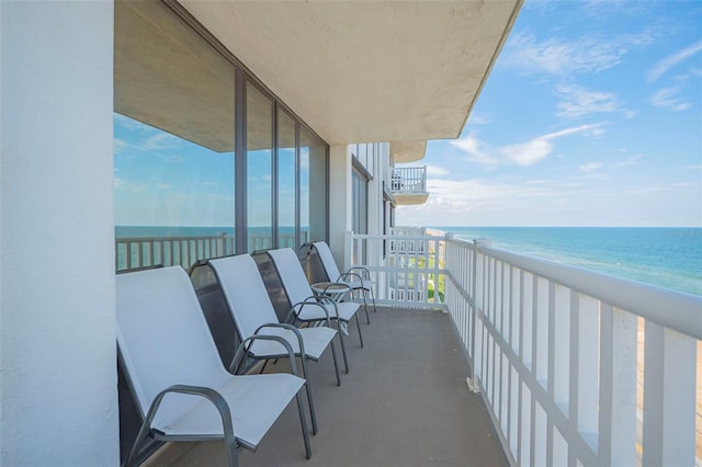 balcony featuring a water view and a view of the beach