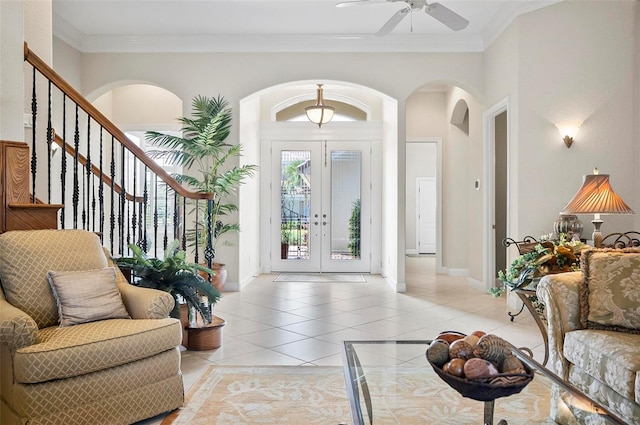 tiled entryway featuring crown molding, ceiling fan, and french doors