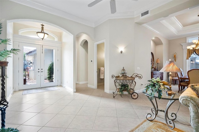 tiled foyer with crown molding, french doors, and ceiling fan