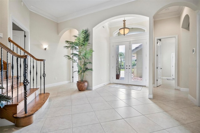 tiled entryway with ornamental molding and french doors