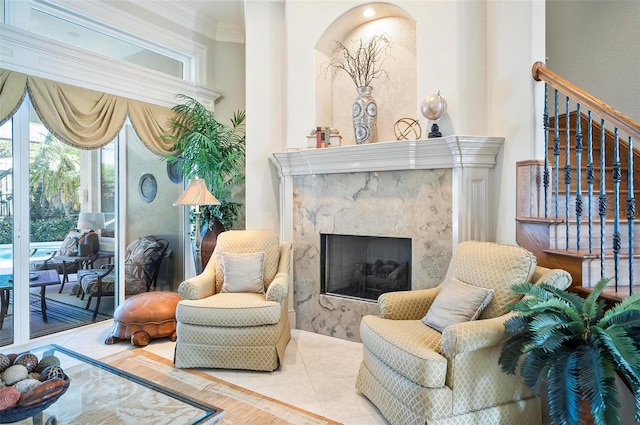 living area with ornamental molding, a high end fireplace, and light tile patterned floors